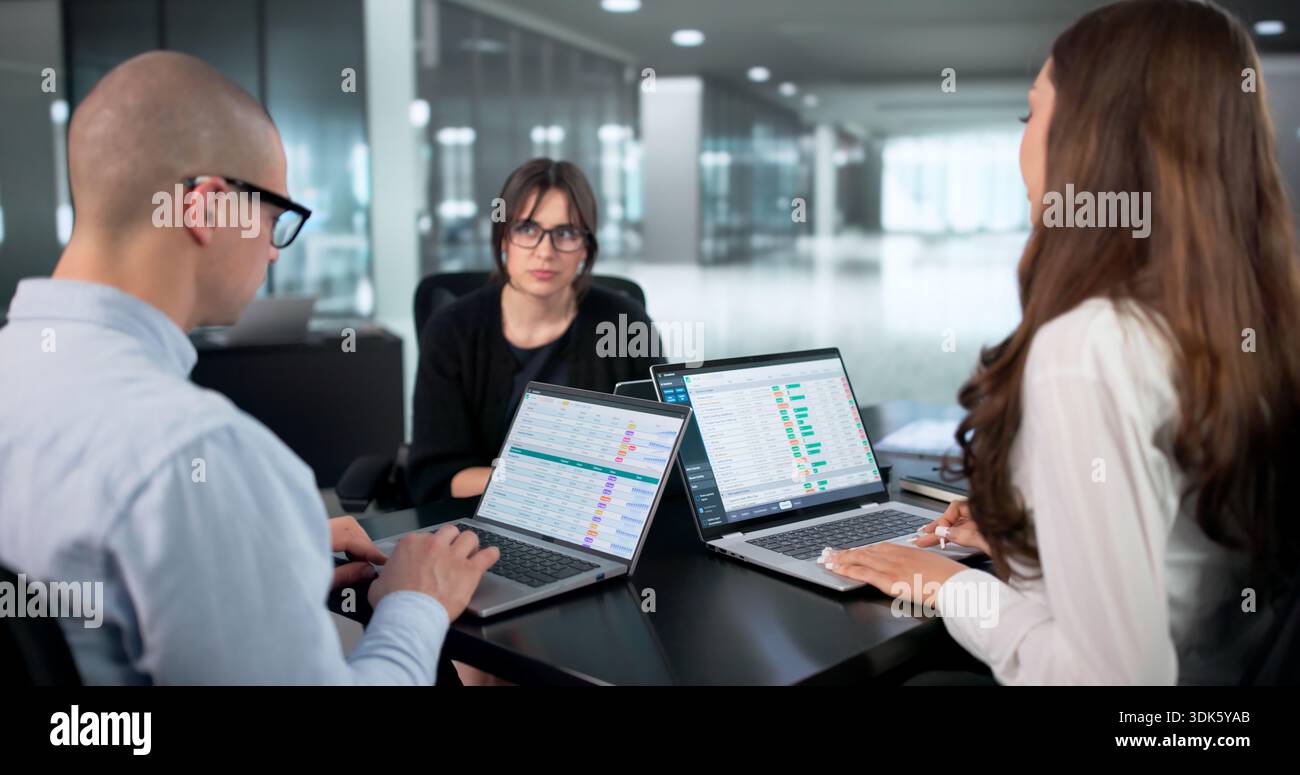 Busy Professionals Collaborating In Modern Office, Analyzing Data Report Together. Stock Photo