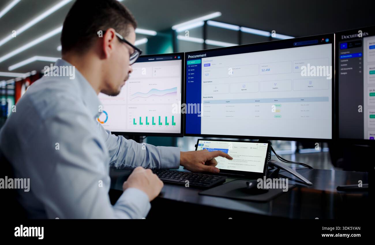 Busy Hispanic IT Specialist Multitasking On Small Desktop Computer Screen. Stock Photo