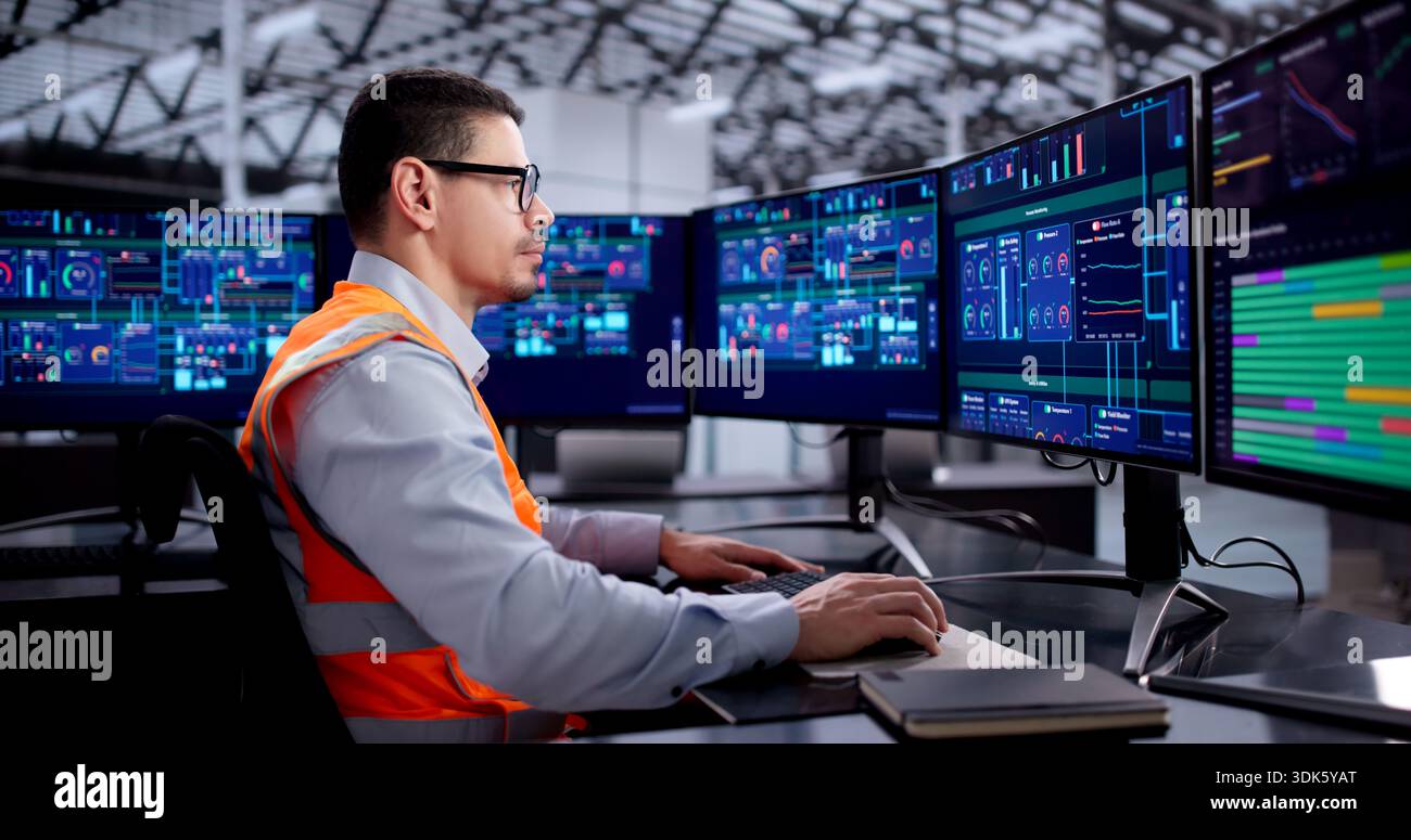 Hispanic Engineer Operating Scada System For Efficient Industrial Production Line Stock Photo