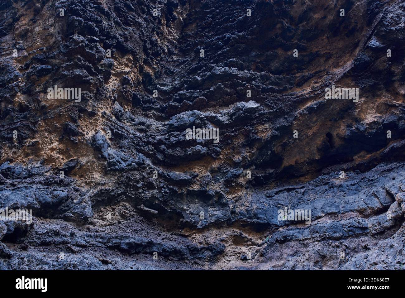 Detailed texture of rough volcanic lava rock surface with layered ...