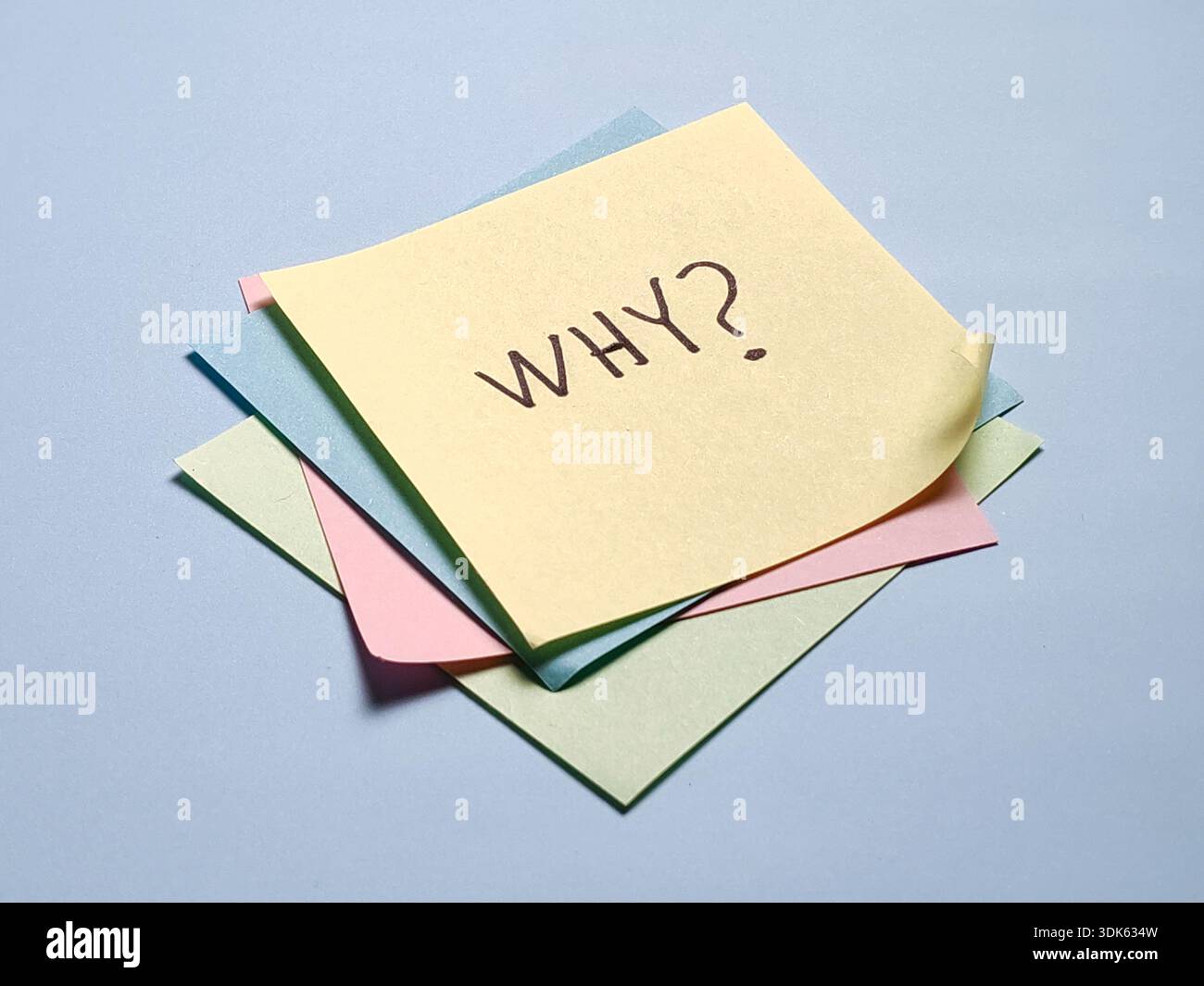 Stack of colorful sticky notes with handwritten why text for brainstorming and creative problem solving Stock Photo