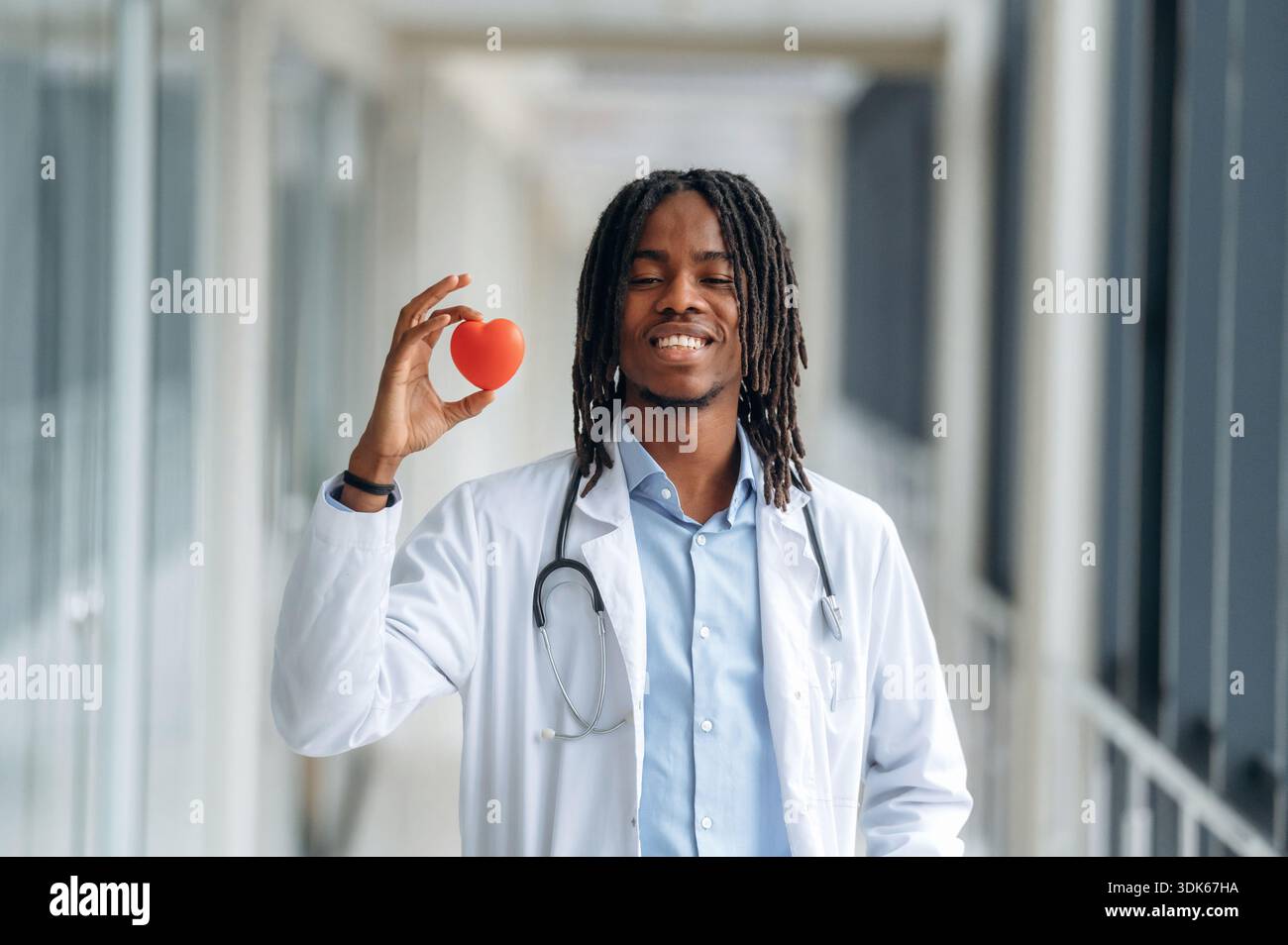 Samall Doctor Small heart in hand, cardiologist. Young male black doctor is in the ...