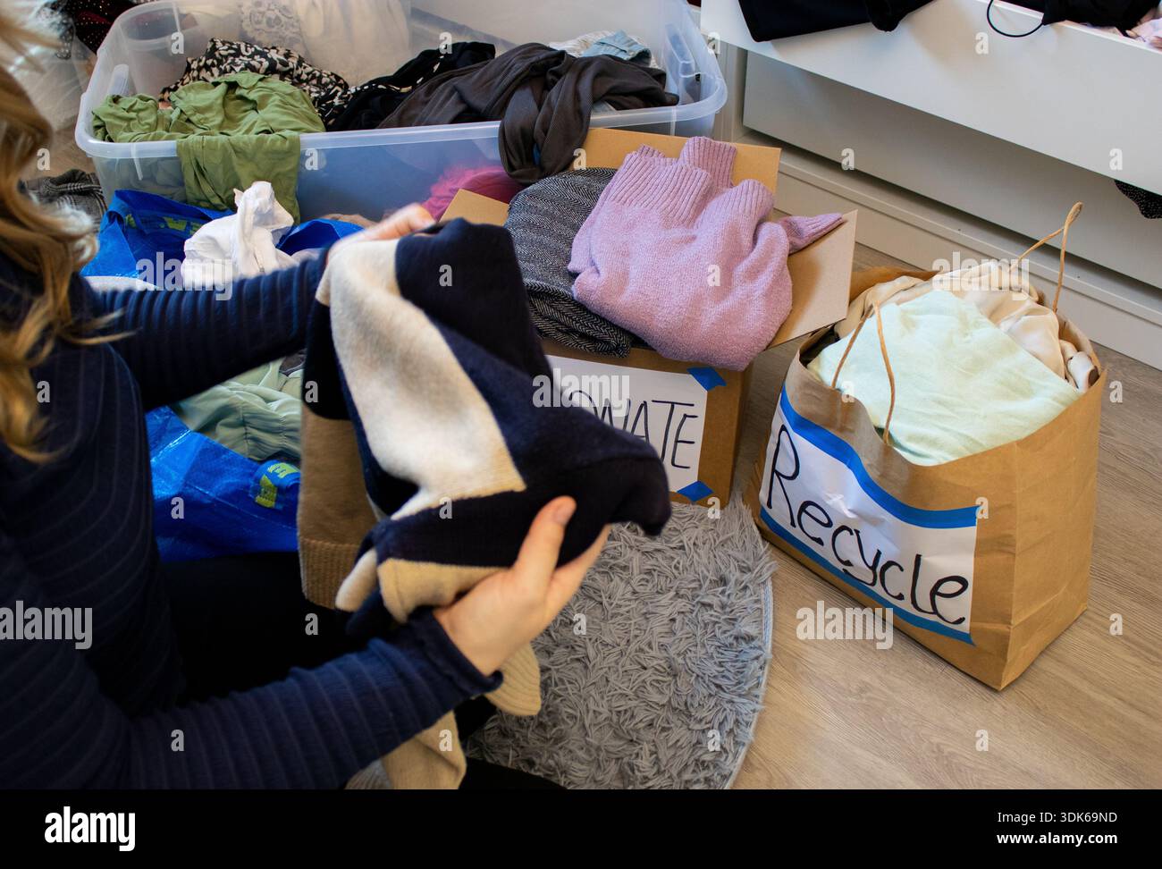 Segregate Clothes Close up of a young woman sorting clothes from her wardrobe for ...