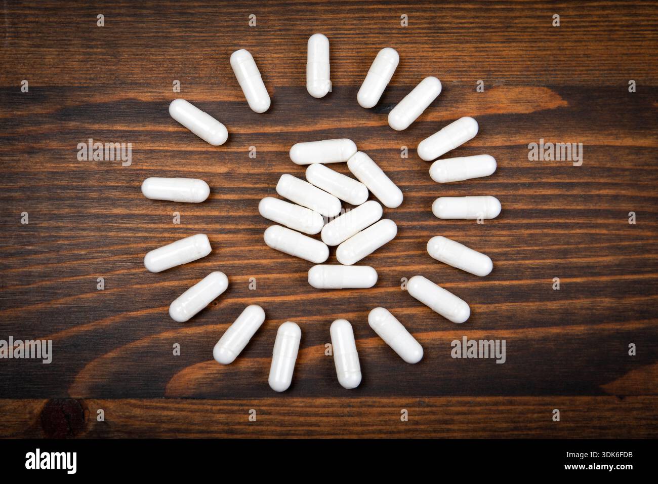 White Medical Capsules Forming Circular Arrangement On Wooden Surface ...