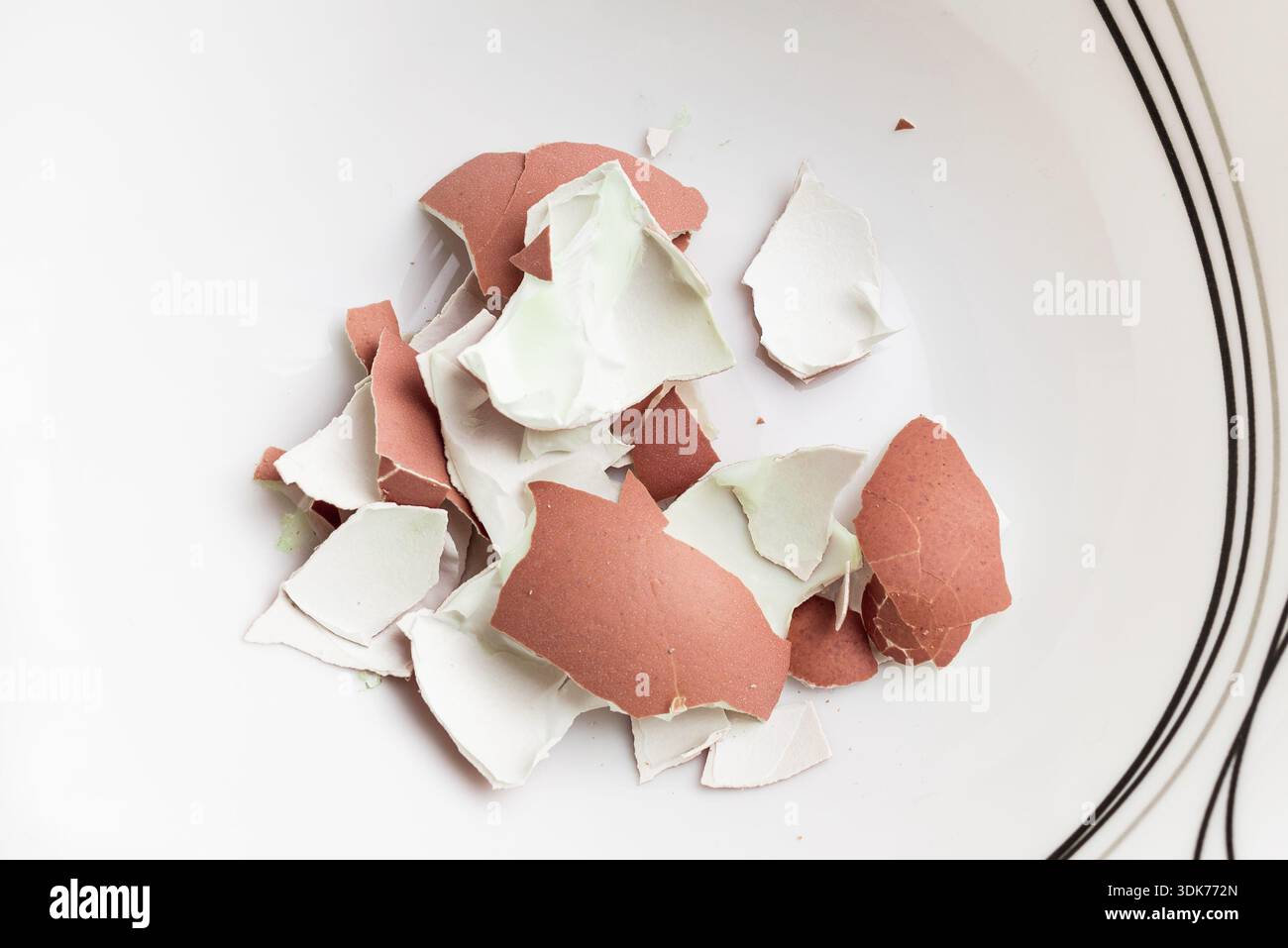 Peeled eggshells on a white plate, close-up. Top view. Stock Photo