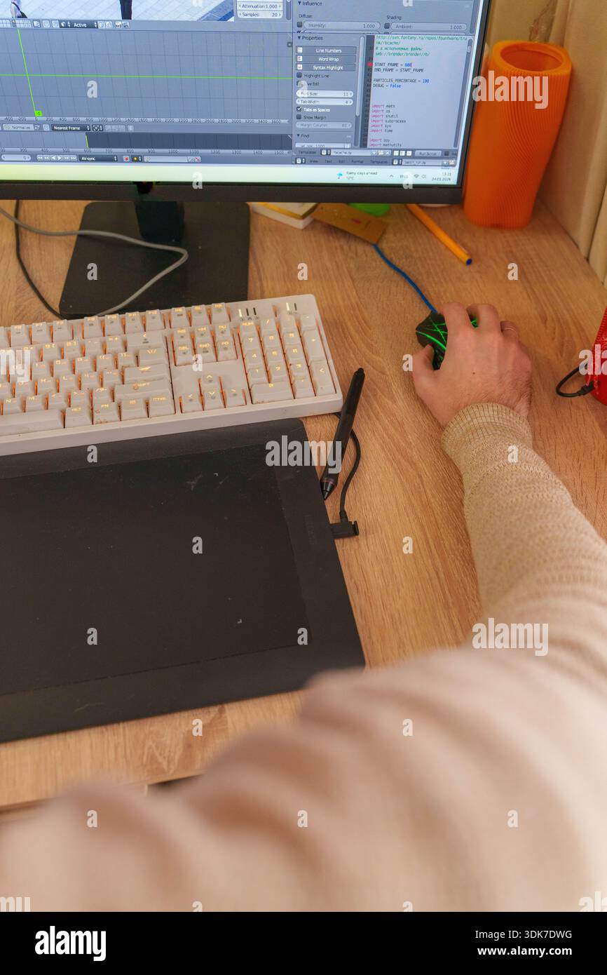 Person working on 3D animation at desk with graphics tablet and mechanical keyboard Stock Photo