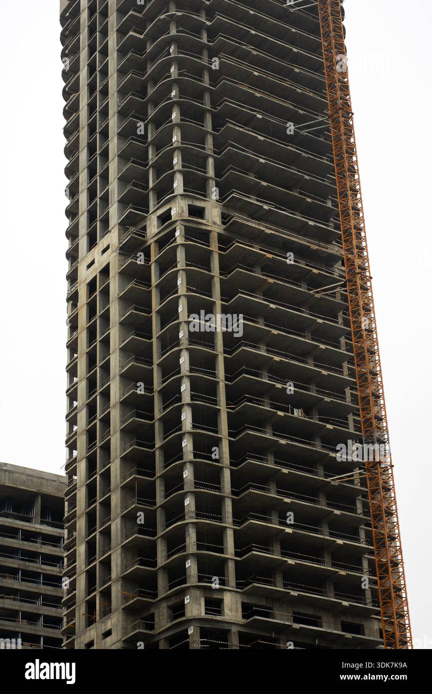 unfinished concrete skyscraper frame under construction, towering ...