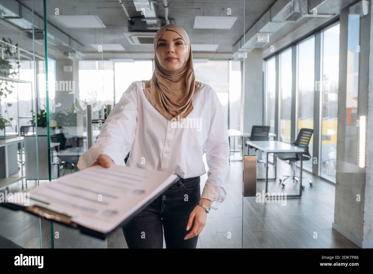Paperwork, documents in hand. Muslim woman in hijab is in the office ...