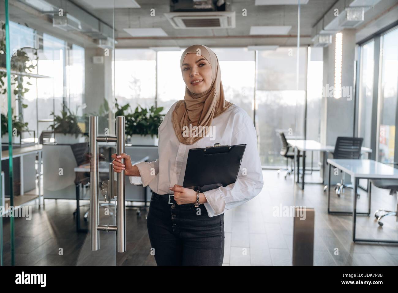 Paperwork, documents in hand. Muslim woman in hijab is in the office ...