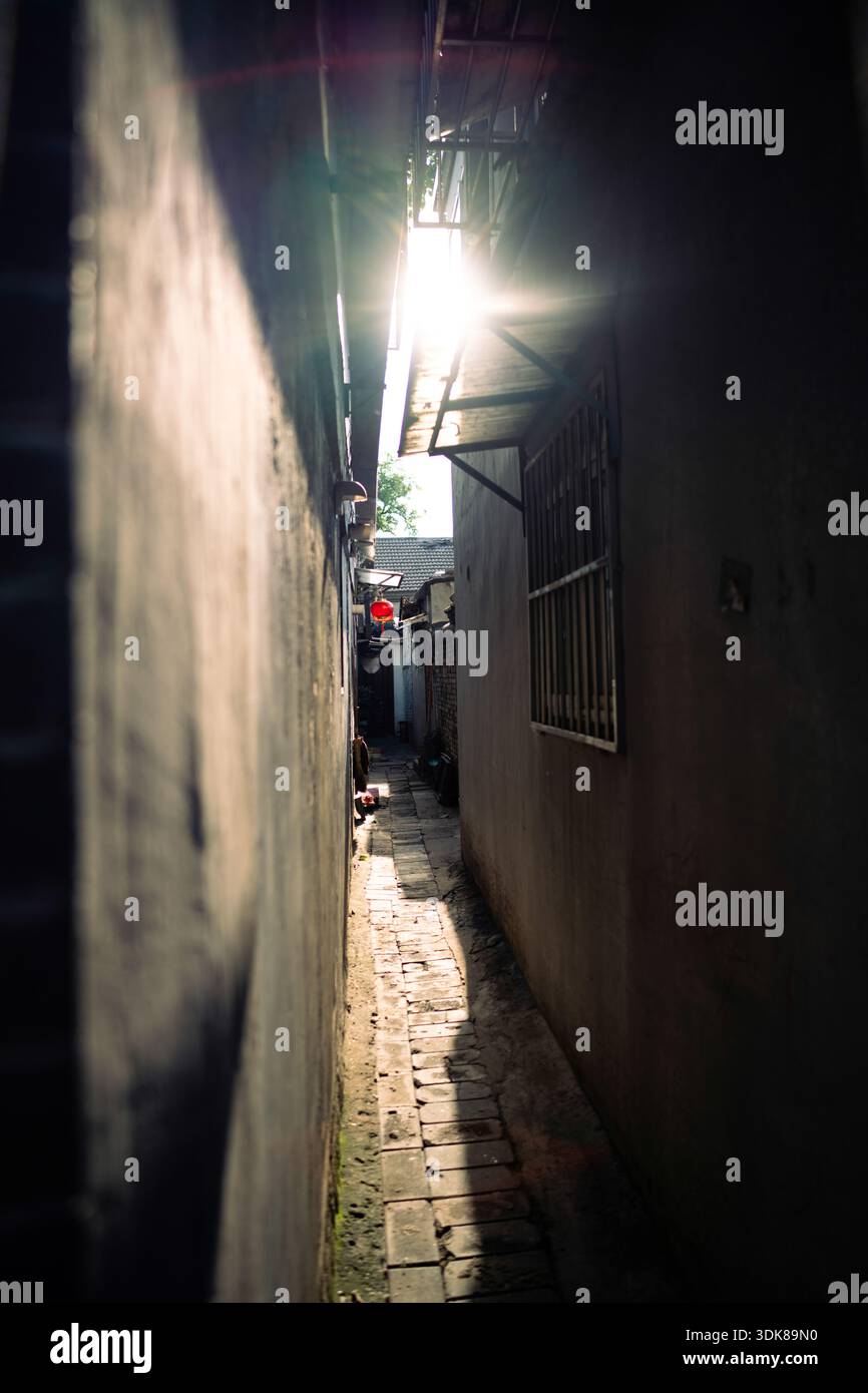 Chinese Hutong Narrow Alley Sunlight Backlit Shadow Dramatic Urban Scene Stock Photo