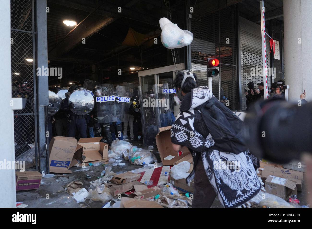Protesters throw trash at federal police blocking a loading dock at the ...