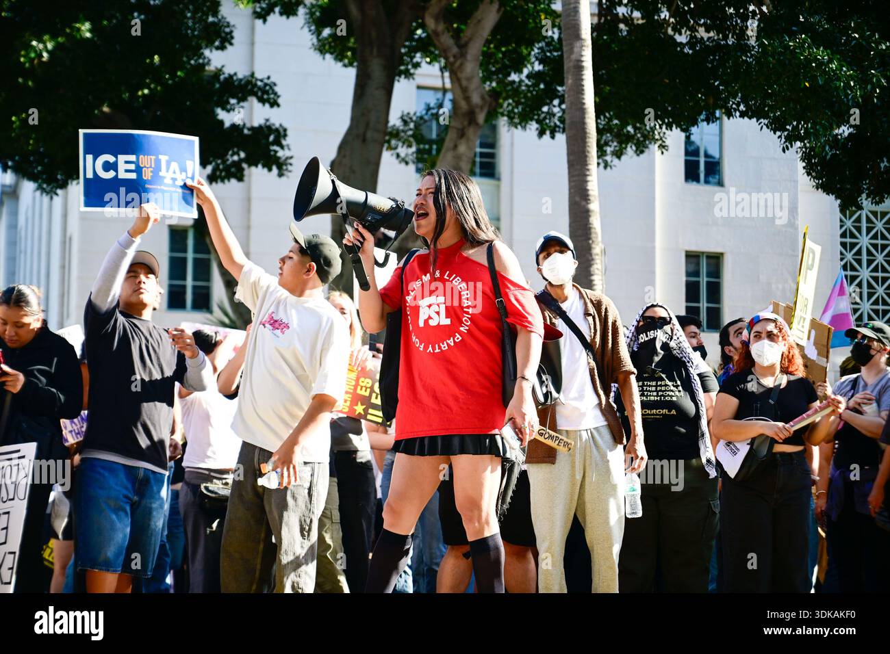 A woman shouts on a megaphone while thousands gather in front of the ...