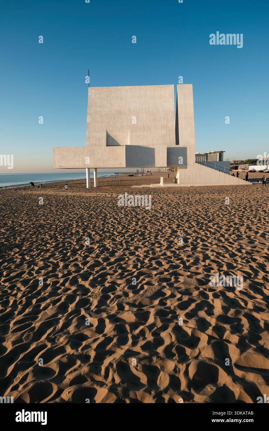 Vertical architectural shot of the Seashore Chapel, focusing on the sand in the foreground and the concrete stairs leading to the entrance. Stock Photo