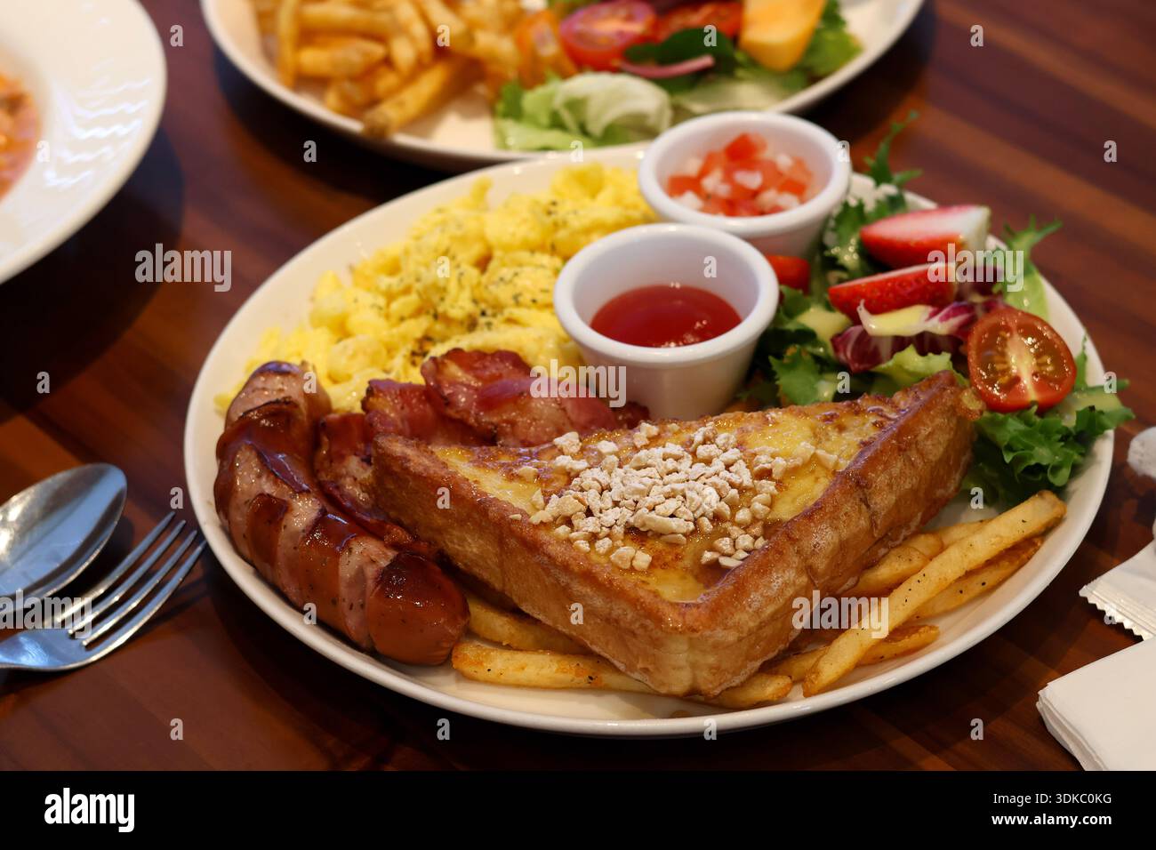 Hearty breakfast plate with toast, scrambled eggs and sausages Stock Photo