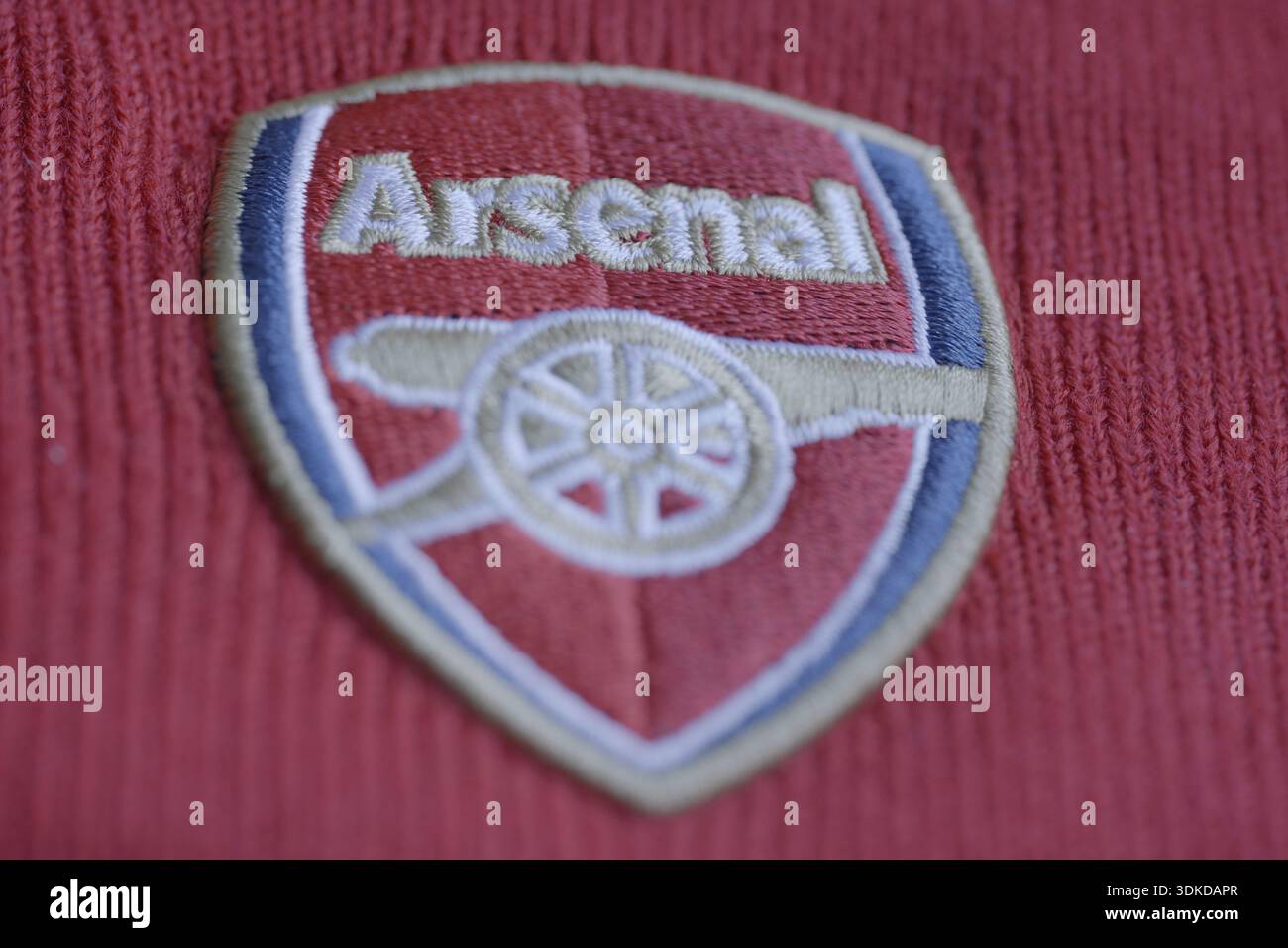 Arsenal football club crest in close up embroidered on a red shirt ...