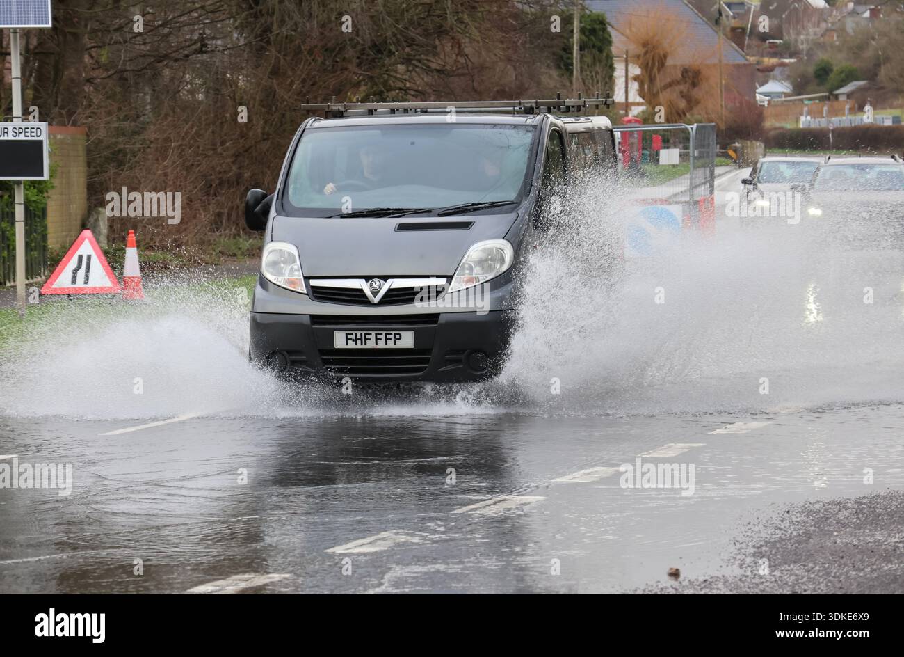 A transit van driving through flooded roads causing high splashing ...