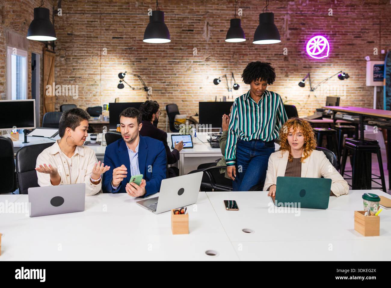 Multi ethnic team collaborating on project in modern office Stock Photo