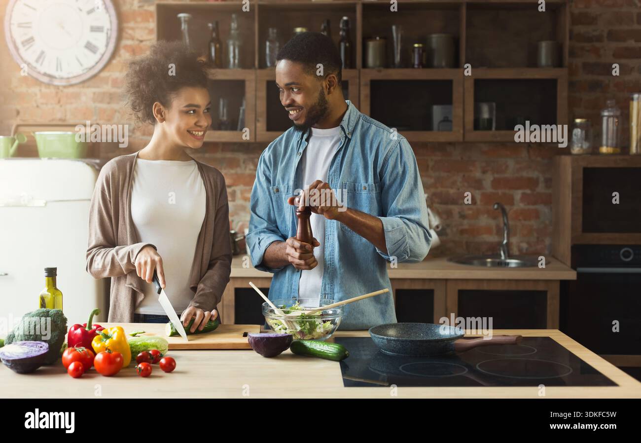 Happy black couple cooking dinner together Stock Photo - Alamy