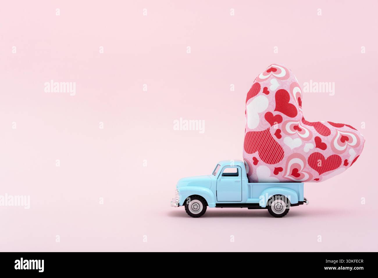 Toy car carrying a heart cushion Stock Photo