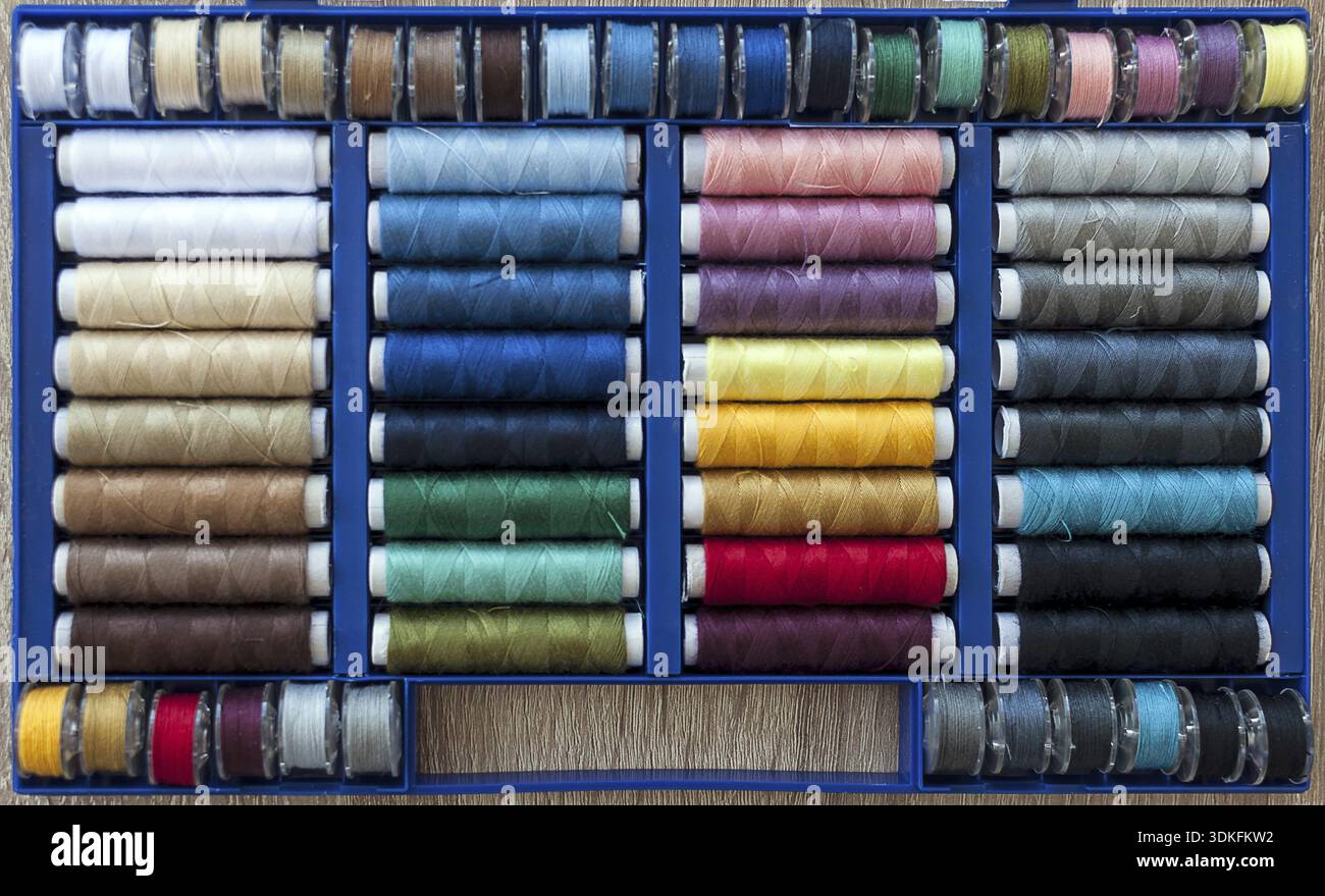 Colored sewing threads on spools arranged in a box Stock Photo