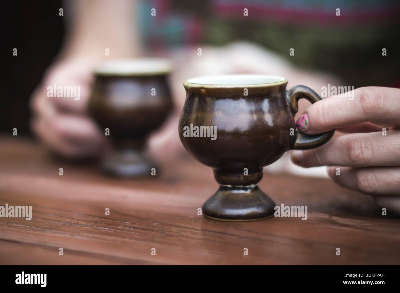 Hands holding coffee cup over dark table Stock Photo