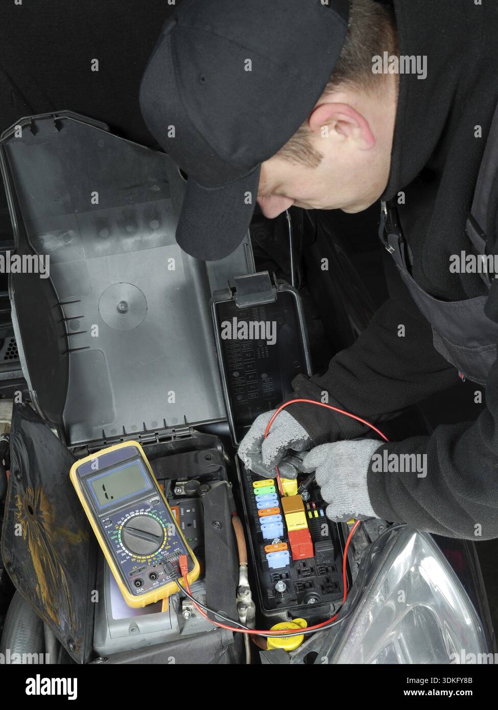 Auto mechanic checking car fuses using multimeter Stock Photo