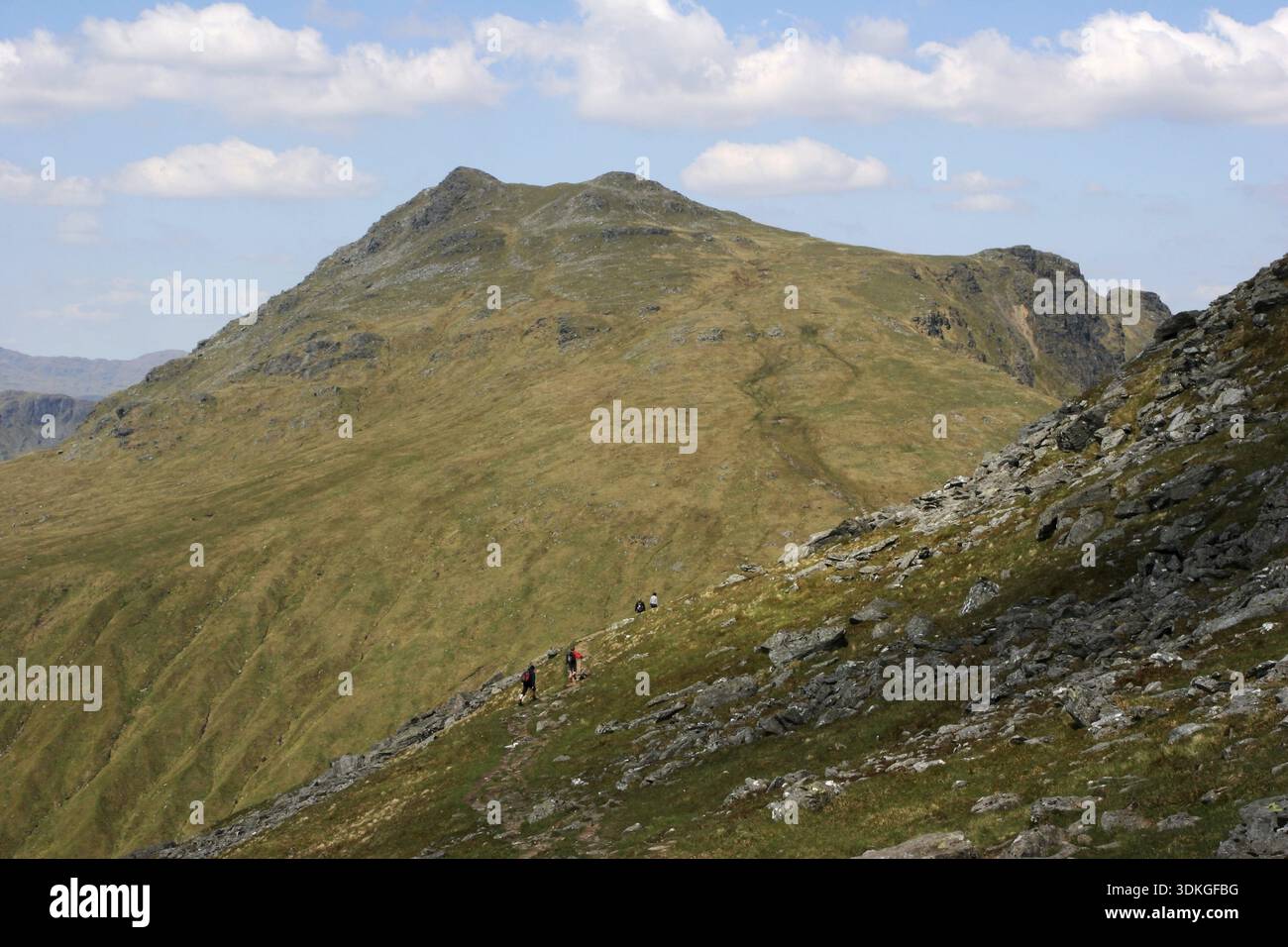 Hillwalkers decending the path on Ben Arthur (The Cobbler) with Beinn Ime in the background Stock Photo