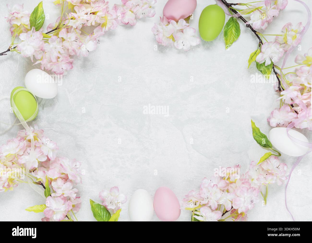 Beautiful delicate Easter composition with pink cherry flowers and multicolored Easter eggs Stock Photo