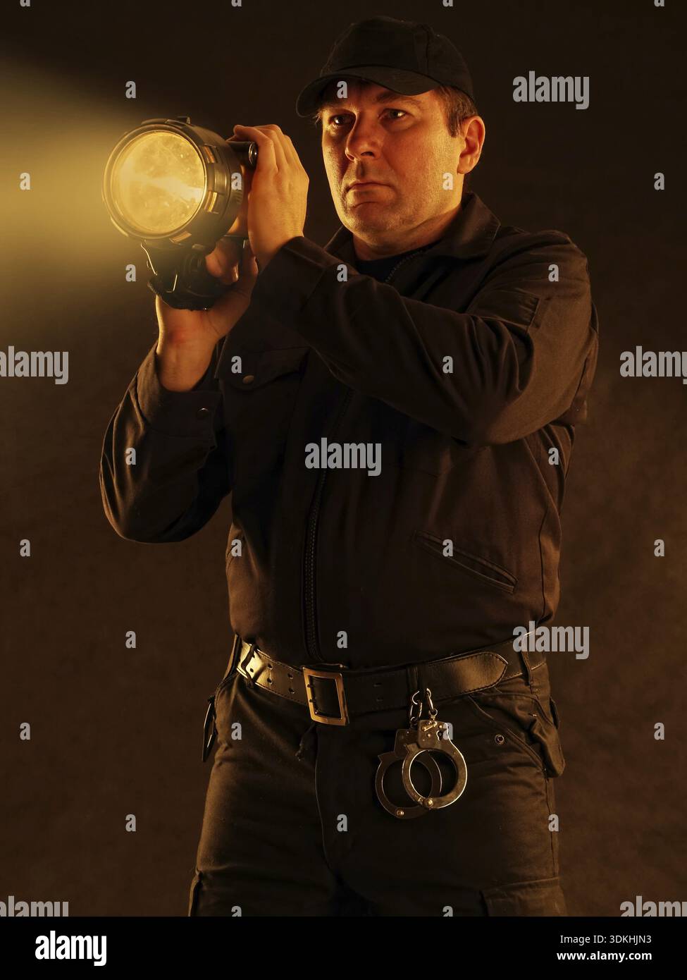 Policeman with lit torch searching the area Stock Photo