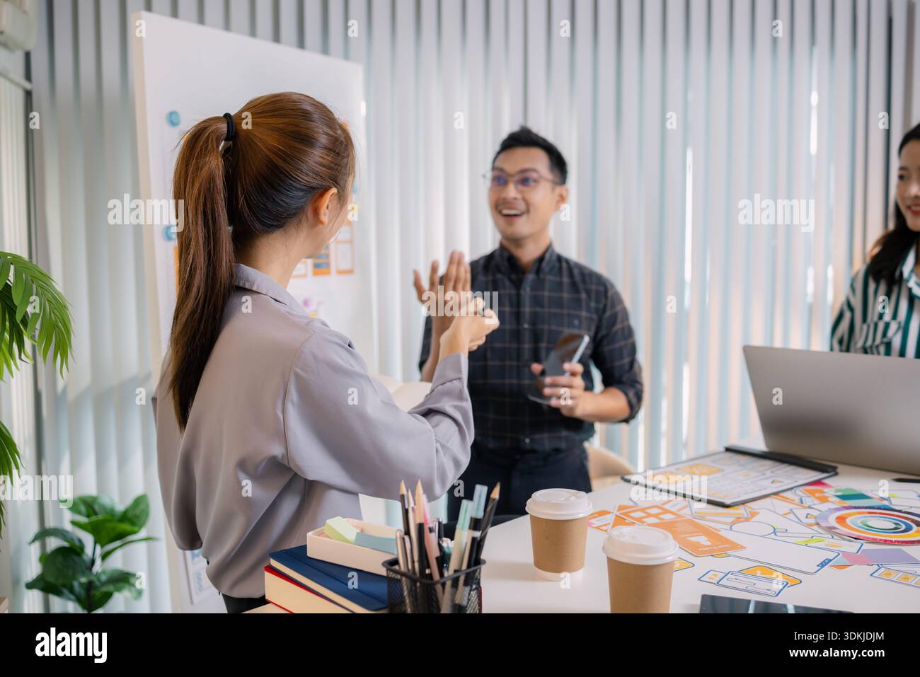 UX/UI designers collaborating during a creative workshop to test interface ideas and exchange feedback for app development, emphasizing teamwork and i Stock Photo