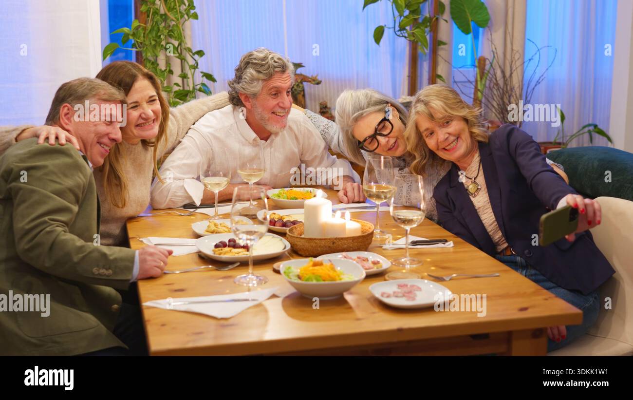 Friends taking group selfie at cheerful dinner party Stock Photo
