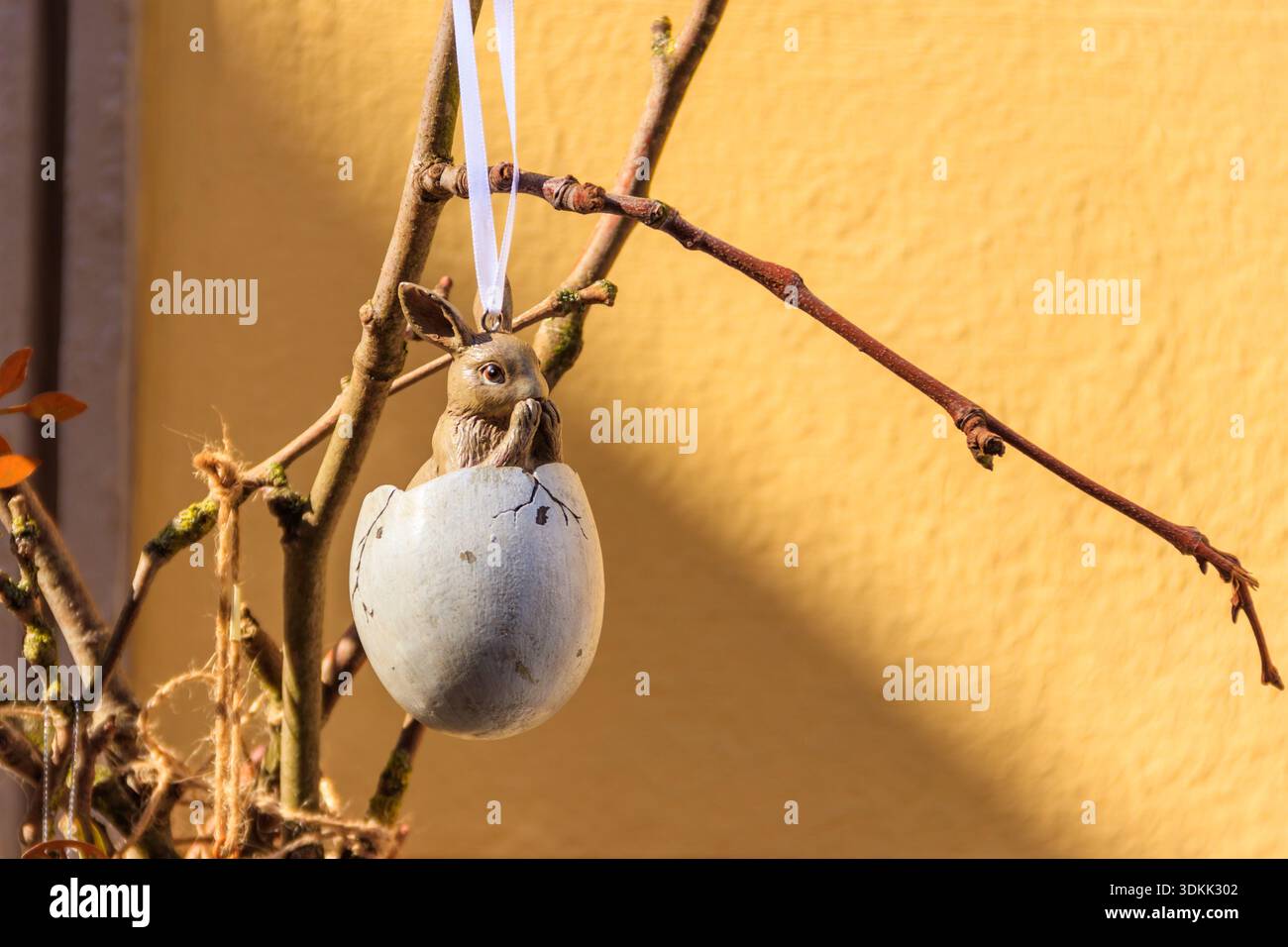 Easter egg with Easter bunny hanging on a twig. Easter decoration Stock Photo