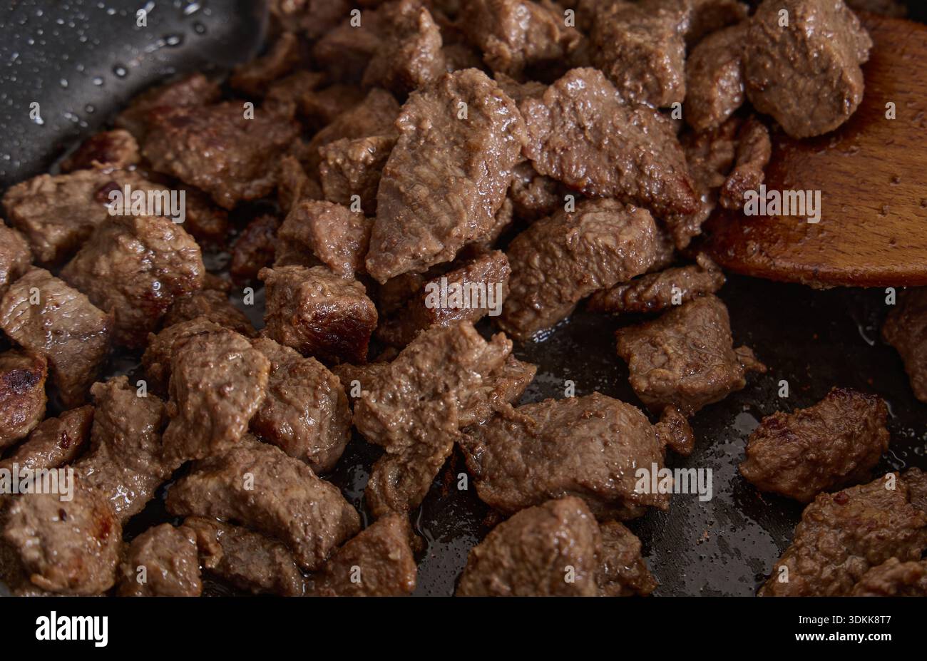 Sizzling Beef Cubes Cooking in Nonstick Pan Stock Photo