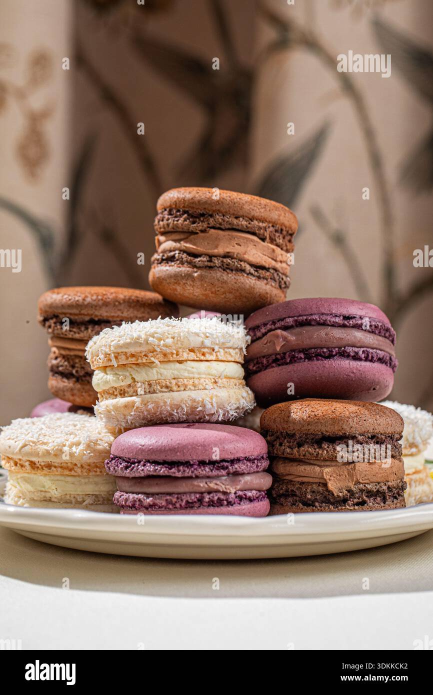 Assorted macarons stacked on decorative plate Stock Photo