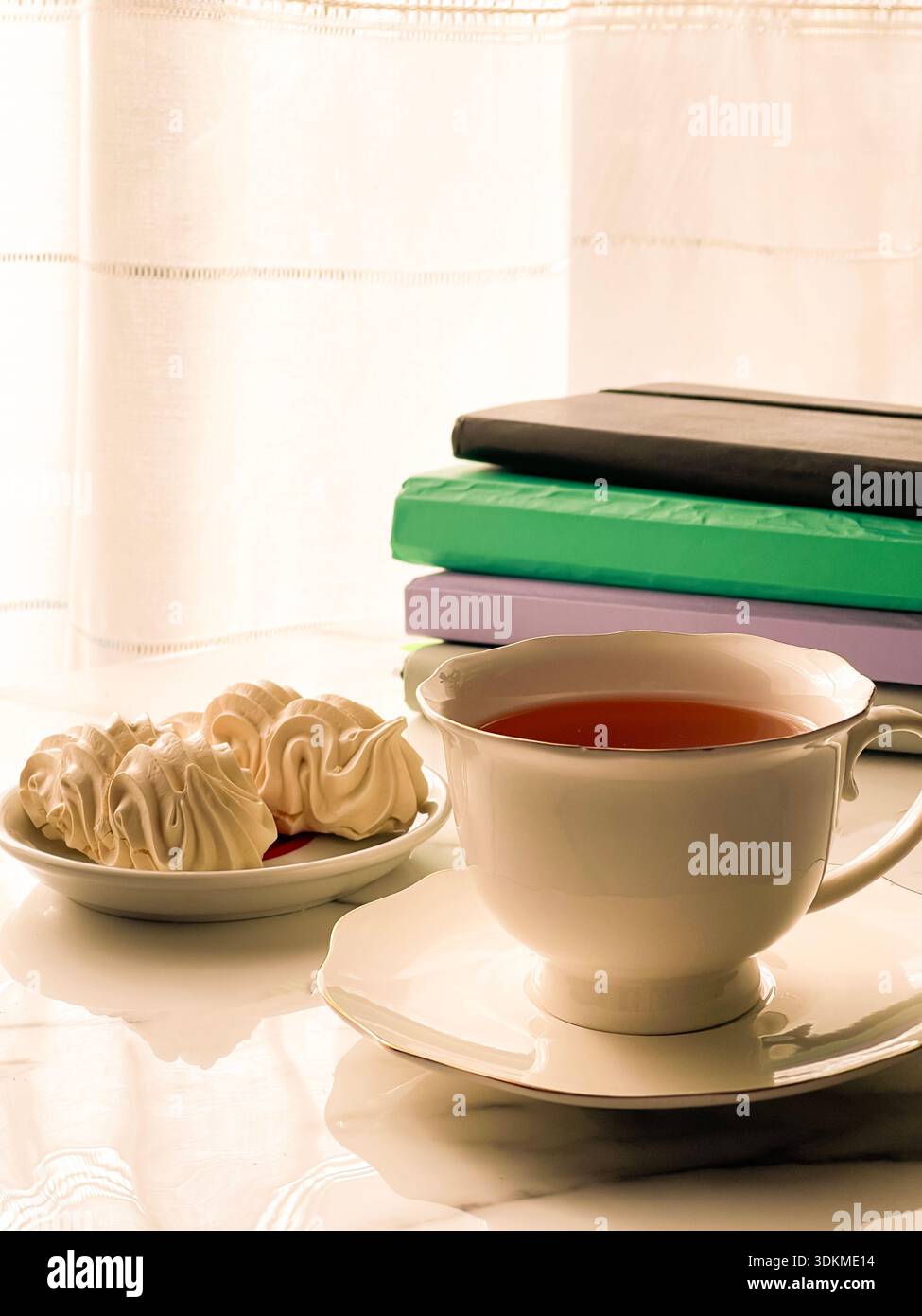 Tea with Zephyr Marshmallows. Cozy tea time with a cup of hot black tea and soft airy Russian zephyr marshmallows on a light table near the window. - Smartphone Captured Stock Image