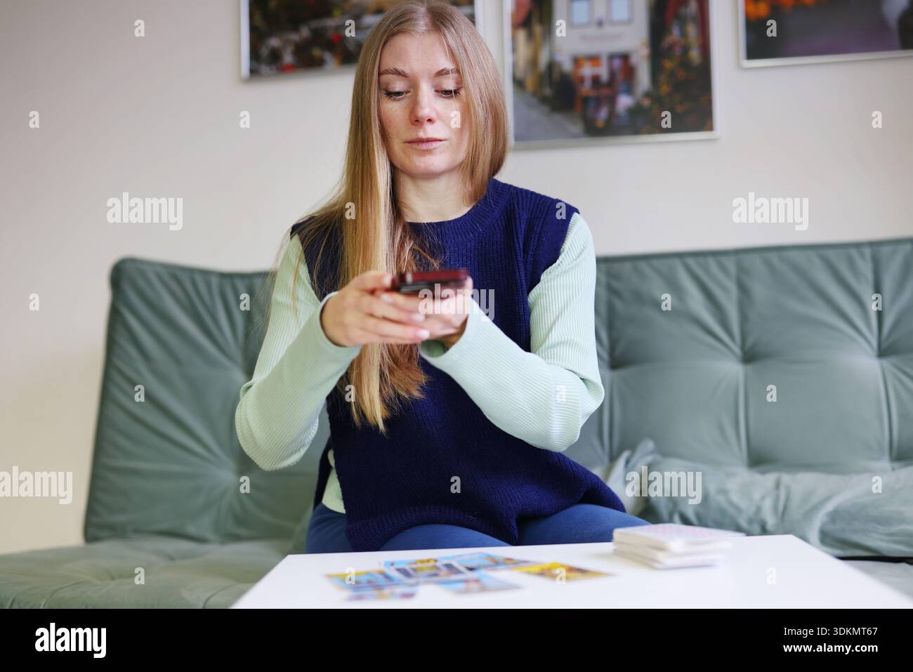 Woman shares tarot card reading with artificial intelligence using smartphone Stock Photo