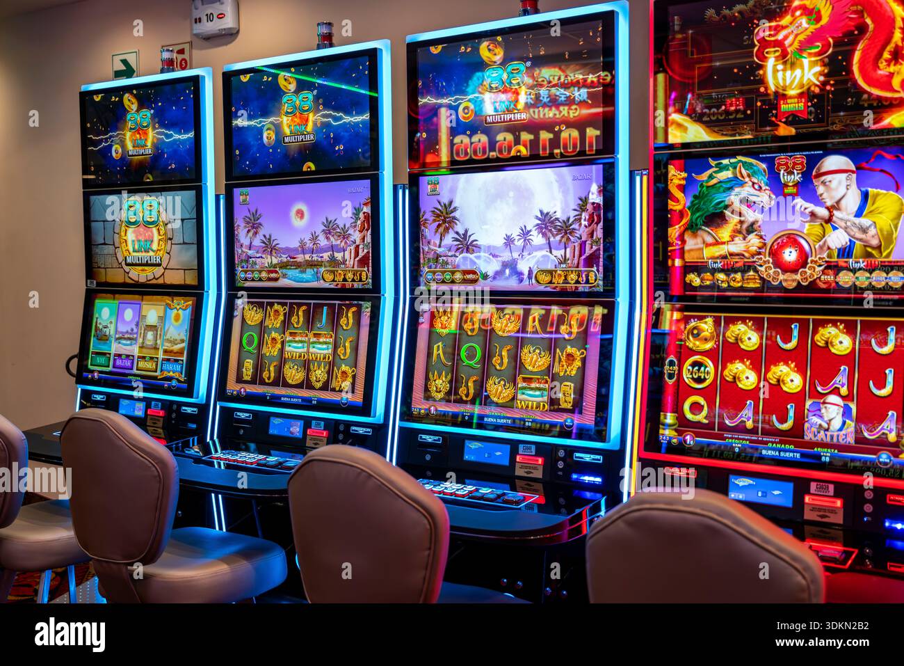 Row of illuminated slot machines in a modern casino with bright