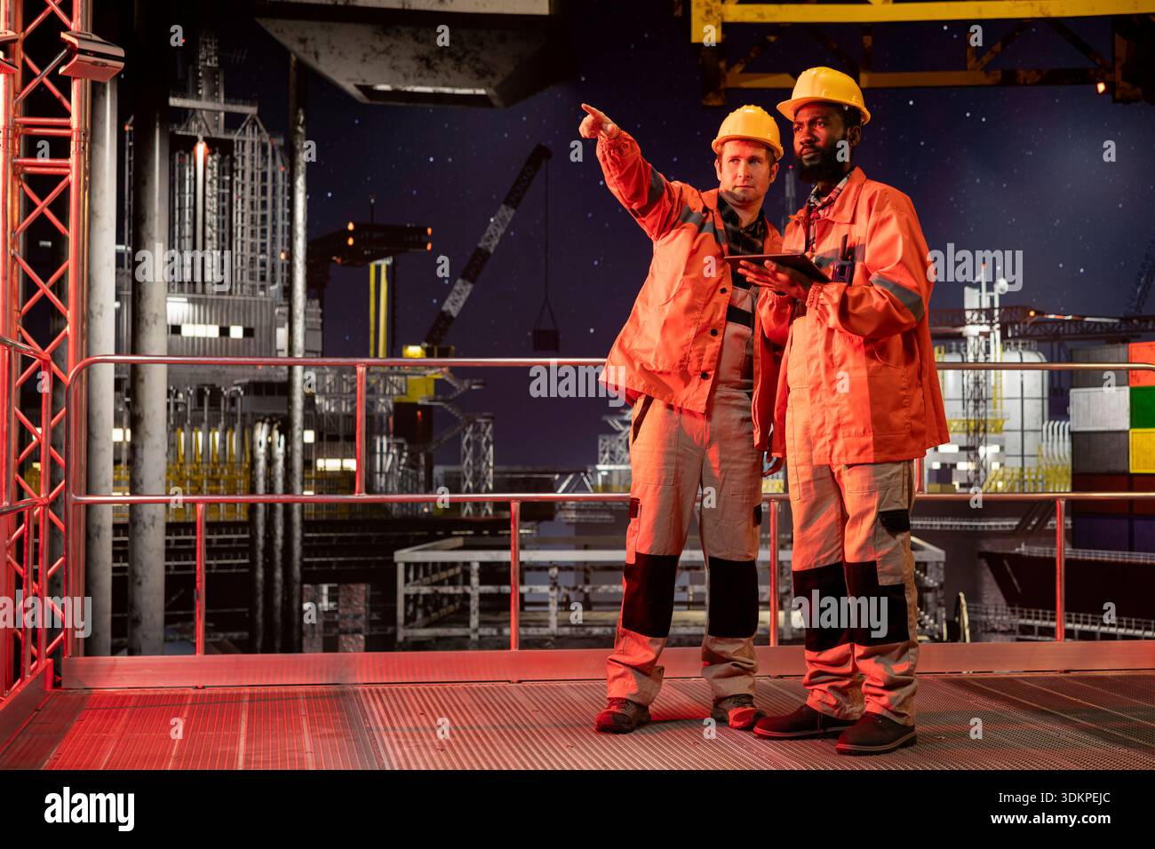 Diverse engineering experts in orange jackets and hard hats analyze ...