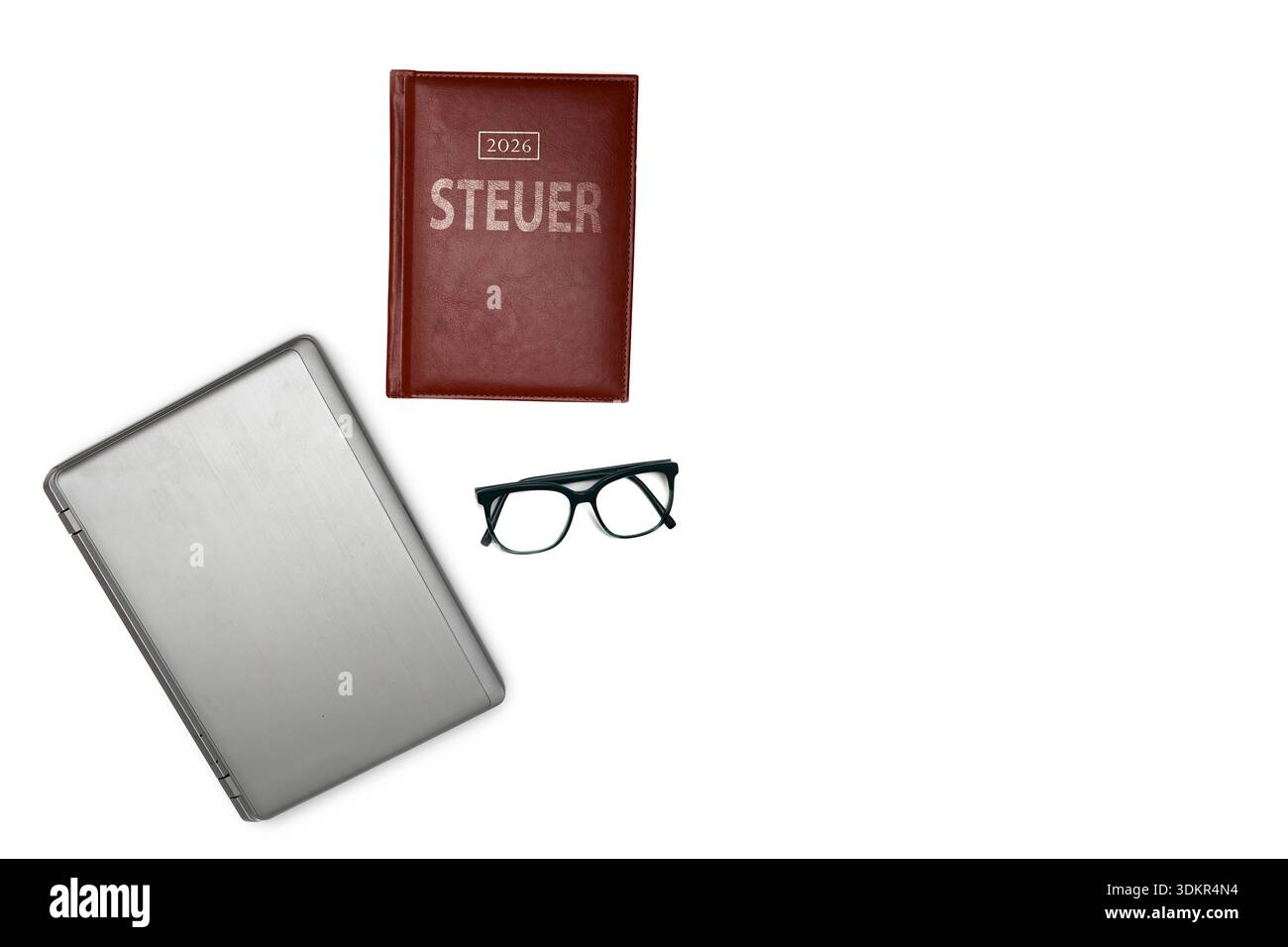 Laptop mit Brille und Notizbuch mit der Aufschrift Steuer, steht für Finanzorganisation, Buchhaltung, Planung und professionelle Vorbereitung von Steu Stock Photo