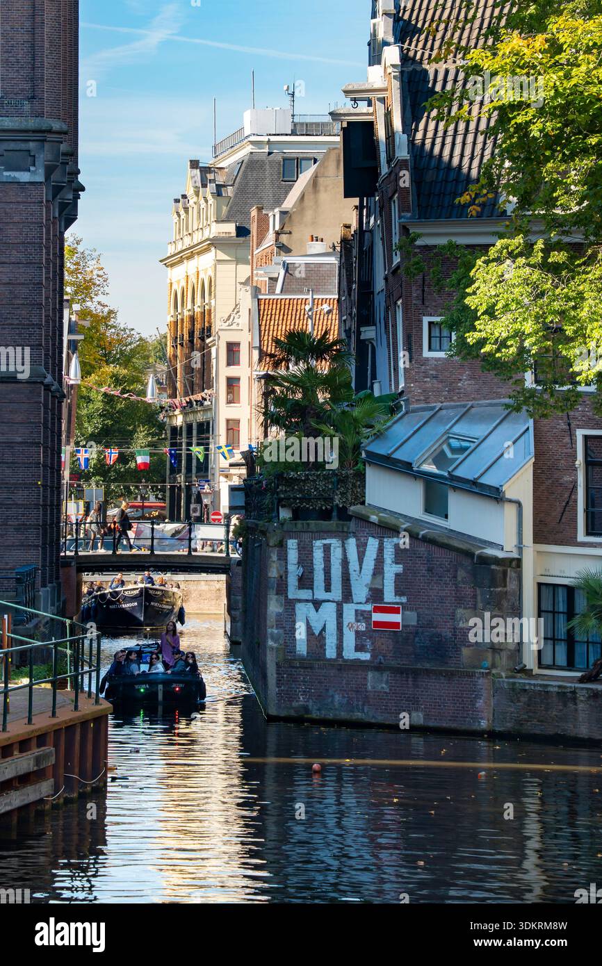 Canal boats carrying tourists on guided tours of the canals of Amsterdam in the Netherlands Stock Photo
