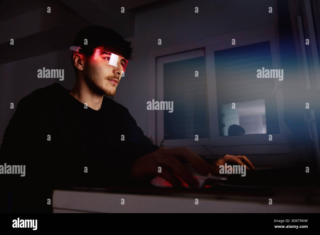 Young man using computer with led cyber glasses Stock Photo
