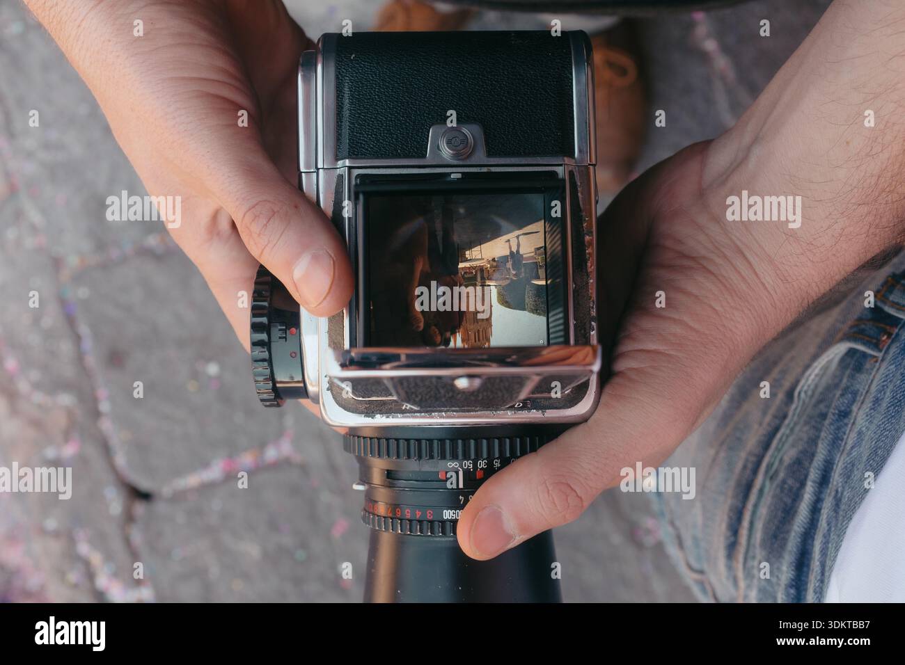 Hands holding vintage medium format camera viewing city Stock Photo