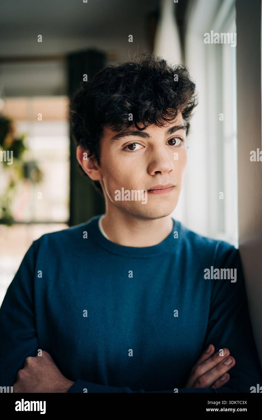 Young man with curly hair looking at camera Stock Photo