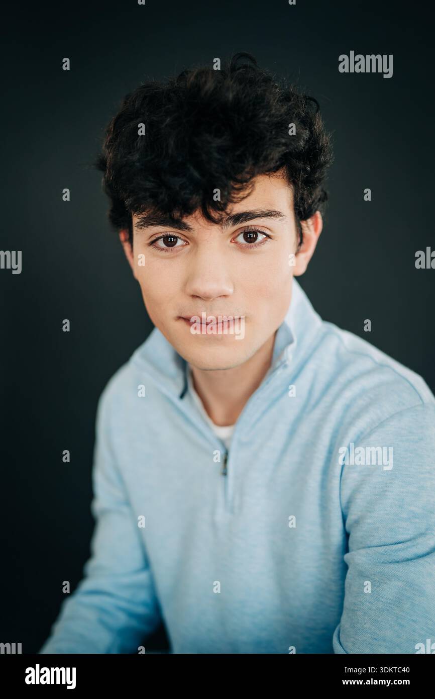Young man with curly hair looking at camera Stock Photo