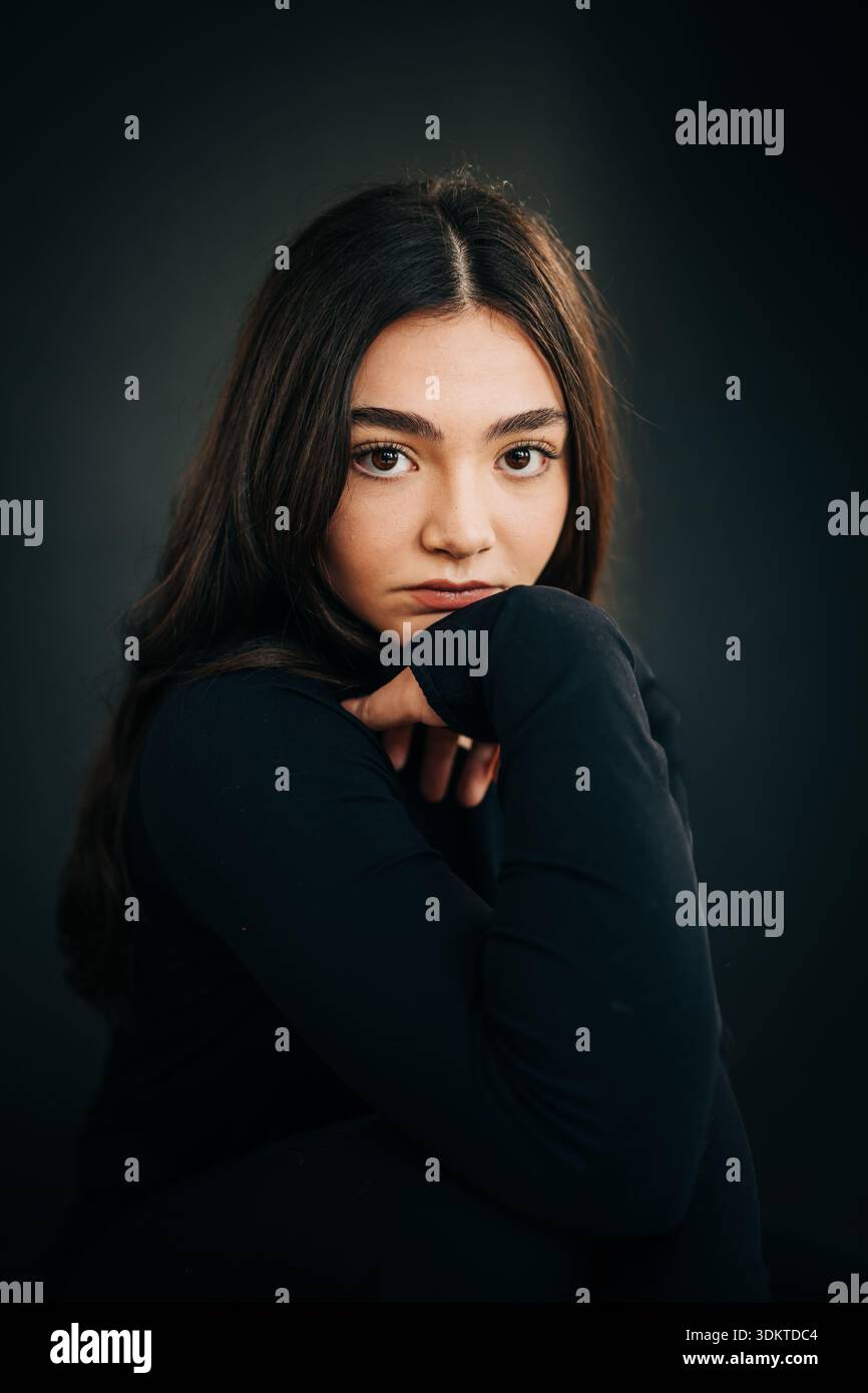 Young woman looking at camera with thoughtful expression Stock Photo