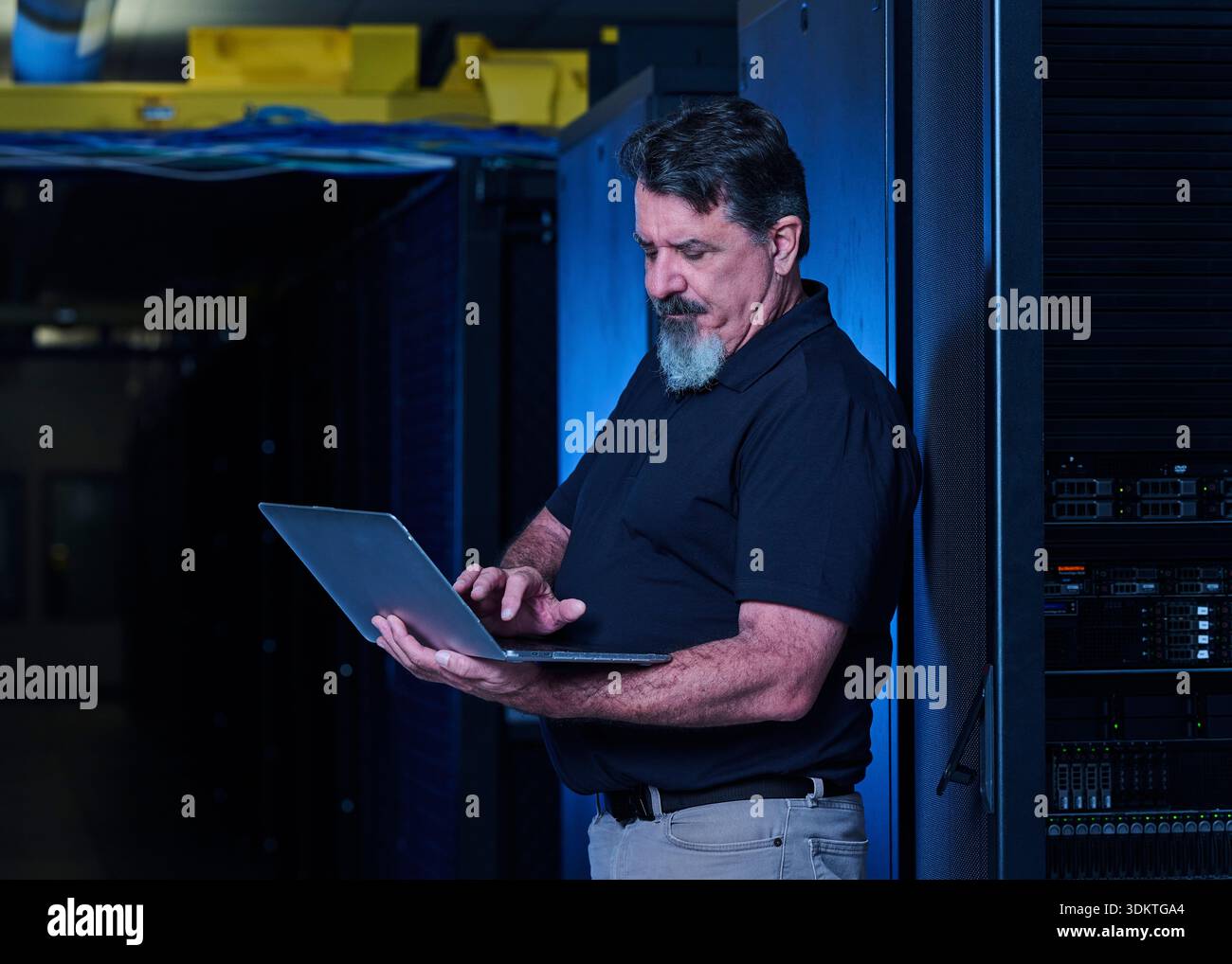 Man using laptop in data center Stock Photo