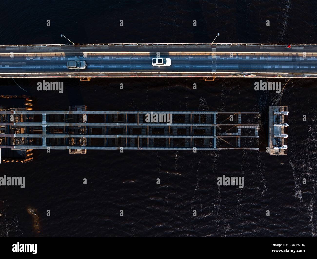 Drawbridge Section View An aerial view shows a drawbridge with one section raised, vehicles on ...