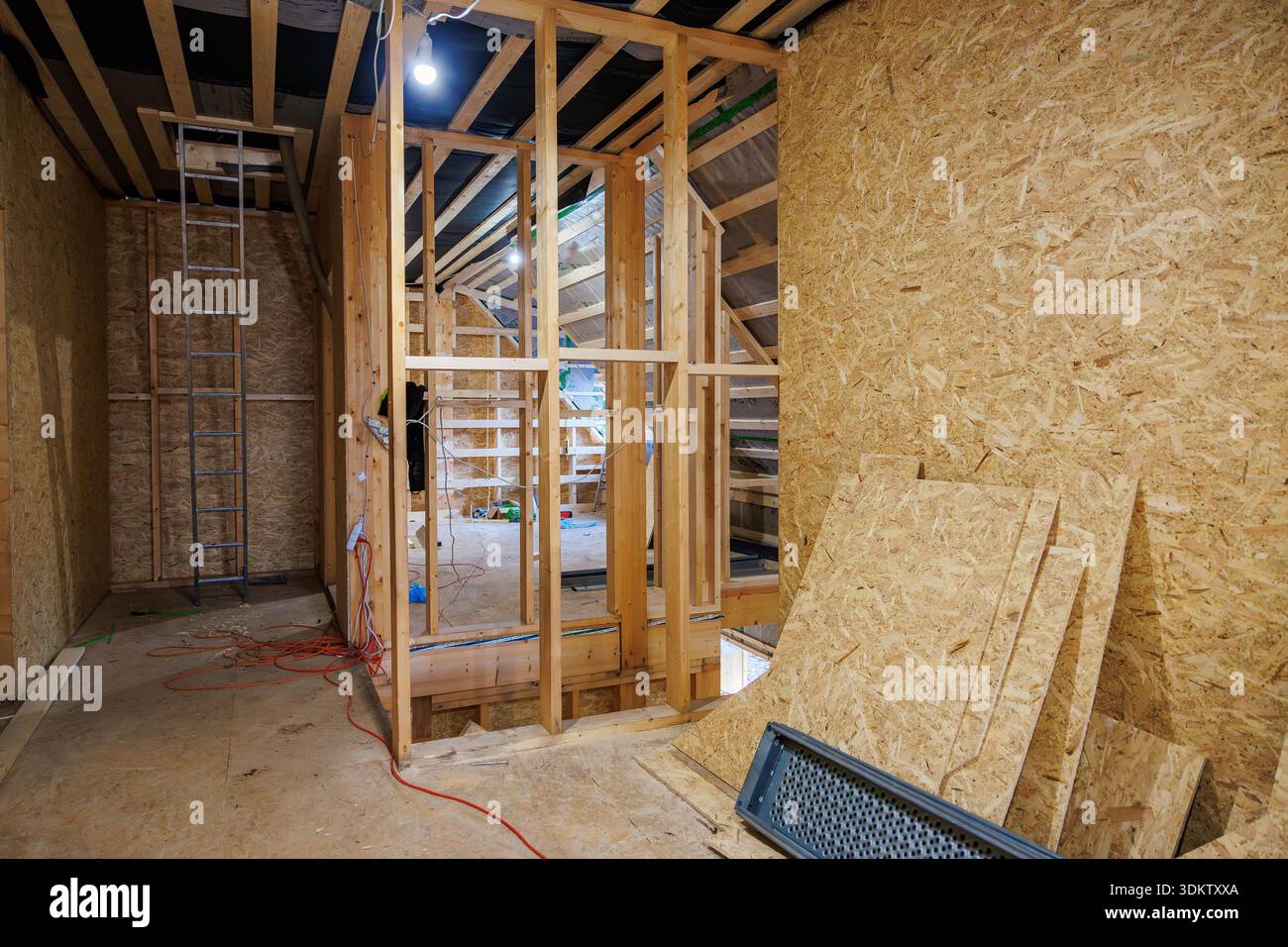 Partially built loft shows exposed wooden studs, OSB walls, and open ...