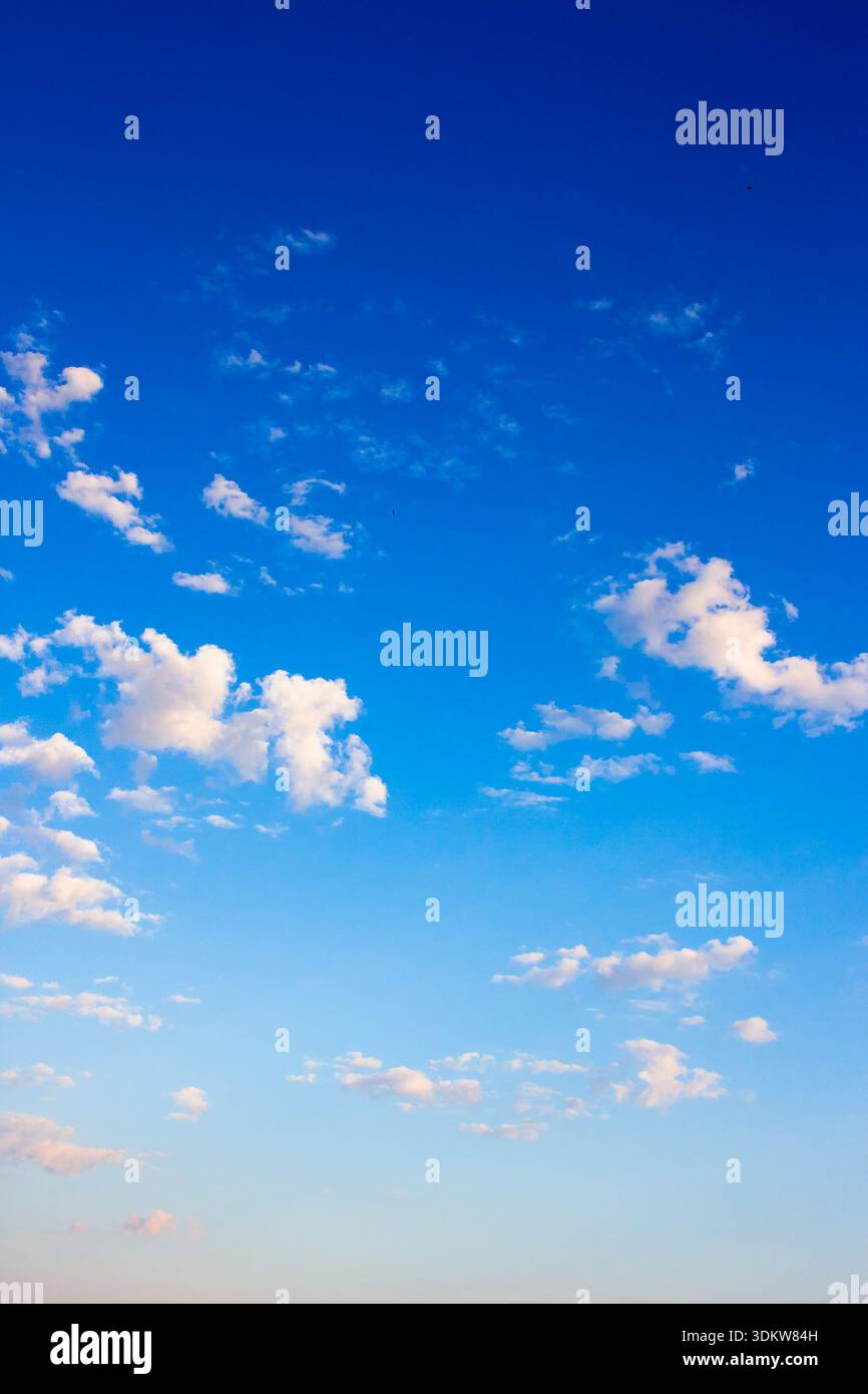 vertical blue sky with white soft clouds. clear atmosphere for summer weather background. peaceful nature on a sunny morning. scenic outdoor pattern f Stock Photo