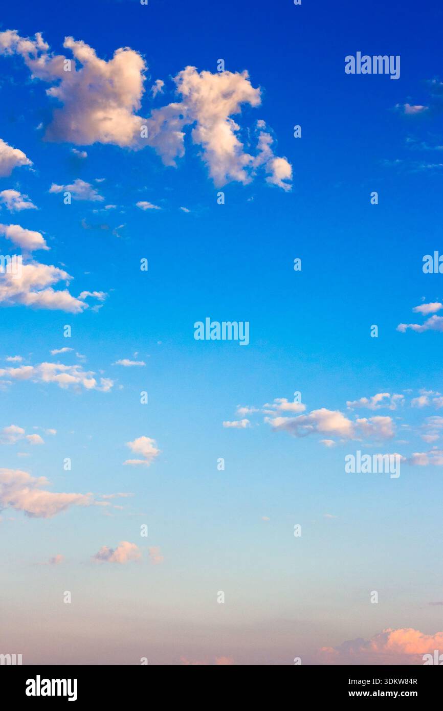 vertical blue sky with white soft clouds. clear atmosphere for summer weather background. peaceful nature on a sunny morning. scenic outdoor pattern f Stock Photo